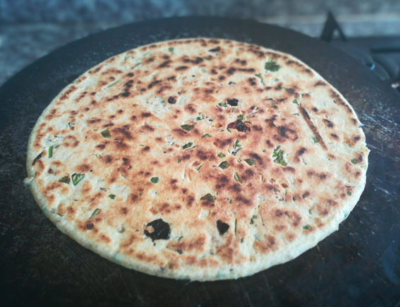 galette de pain plate. des plantes commestibles sont incorporée a la pate juste avant la cuisson.