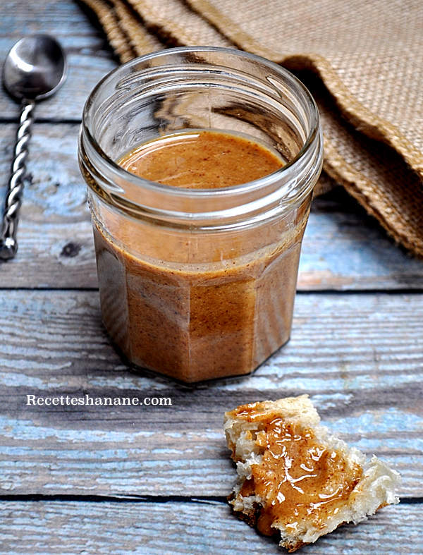 bocal ouvert contenant de l'Amlou et à côté un morceau de pain avec de l'Amlou dessus